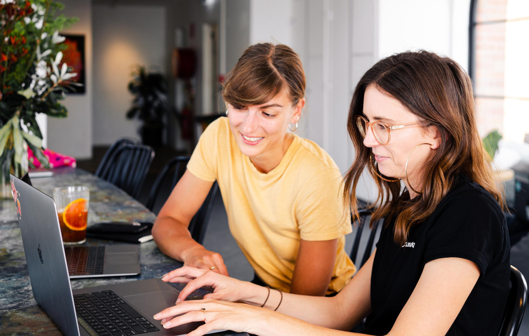 Changes to JobKeeper Payment Scheme. Two young women at home looking at laptop screen.