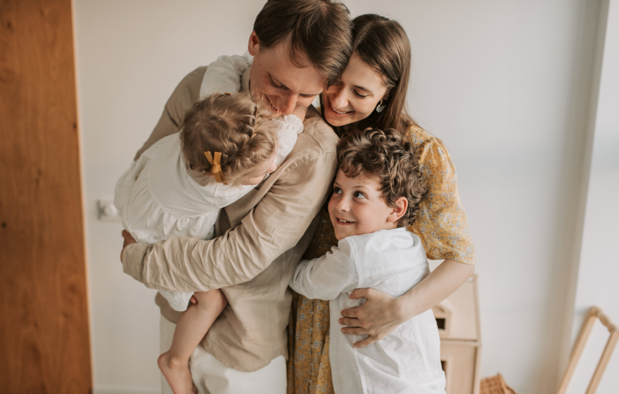 Family of four smiling and hugging